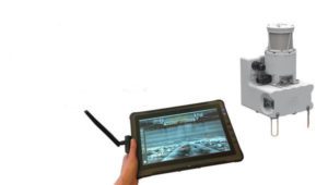 vue en en premier plan d’une tablette tactile durcie, avec une antenne de communication. Et en second plan d’une caméra tournante.