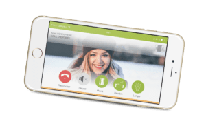 Un écran de smartphone affiche le visage souriant d’une visiteuse, différents modules permettent d’ouvrir la porte, la barrière, d’allumer la lumière ou encore de raccrocher.