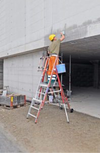 Un opérateur travaille en hauteur sur un mur extérieur