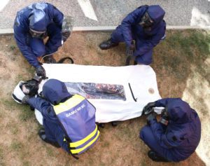 Des secouristes manipulent un sac d’extraction Ouvry dans laquelle se trouve une victime contaminée.