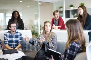 Des femmes et des hommes discutent dans un bureau.