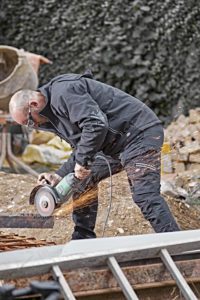 Un artisan porte le pantalon Universal Flex sur le chantier.