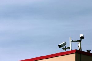 Deux caméras de vidéosurveillance sont perchées sur un toit.