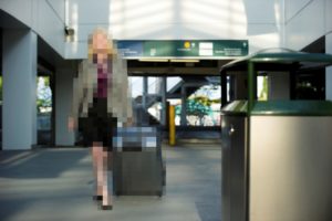 Vue d’une silhouette féminine dans un aéroport, floutée par une mosaïque à des fins de protection de la vie privée.