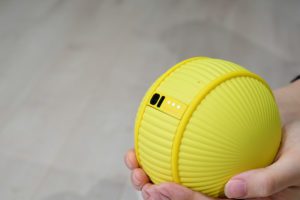 Une boule jaune intelligente qui tient dans la main