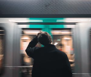 Un parisien se tient devant l’arrivée d’un train.